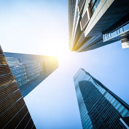 Street view looking up at several skyscrapers against a deep blue sky.