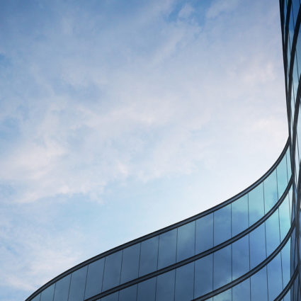 Curved outline of the top of a building with lots of side-by-side windows.