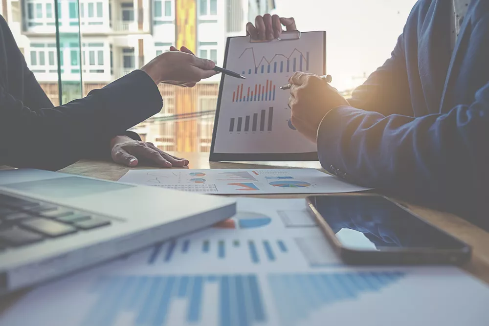 Two employees review financial and accounting data together.