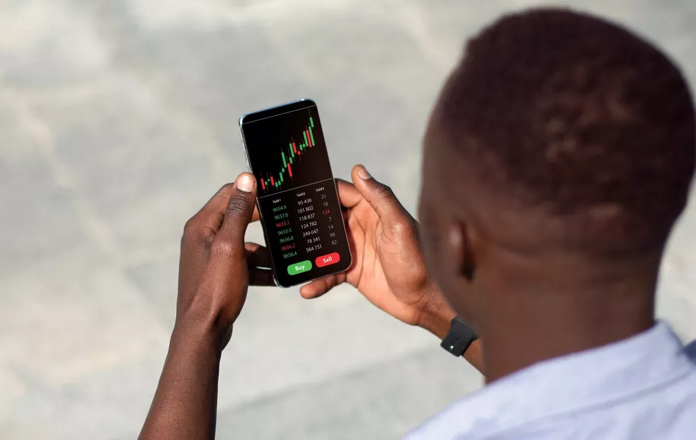 A man checks crypto fluctuations on his phone.