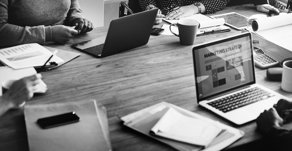 A group of workers strategizes together during a meeting.