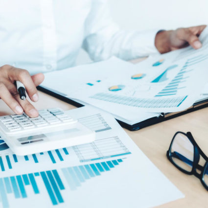 A business person sorts through business accounting statements.