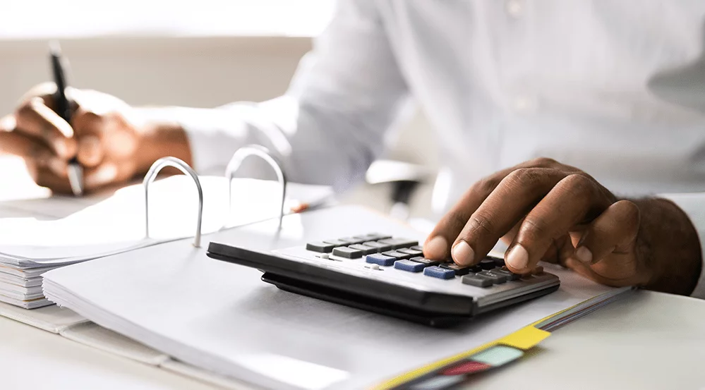 Male using calculator and taking notes.