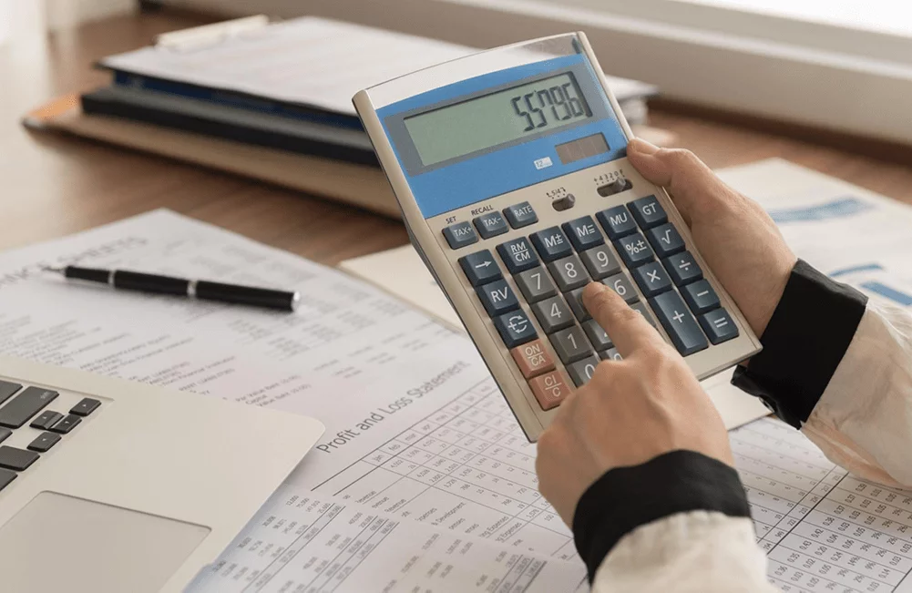 Woman using calculator for bookkeeping.