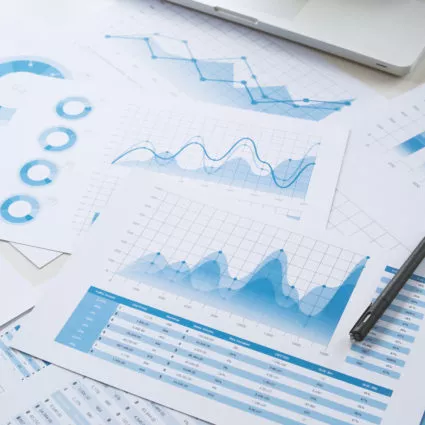 Financial charts and graphs scattered across an office table.
