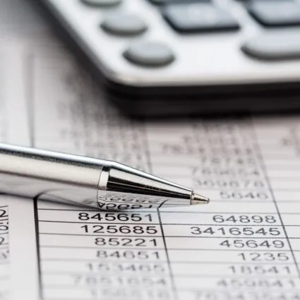 A pen sitting on some financial documents